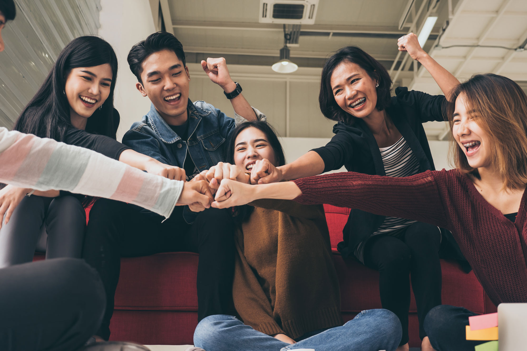 Students fist bumping for a new lifestyle to adapt