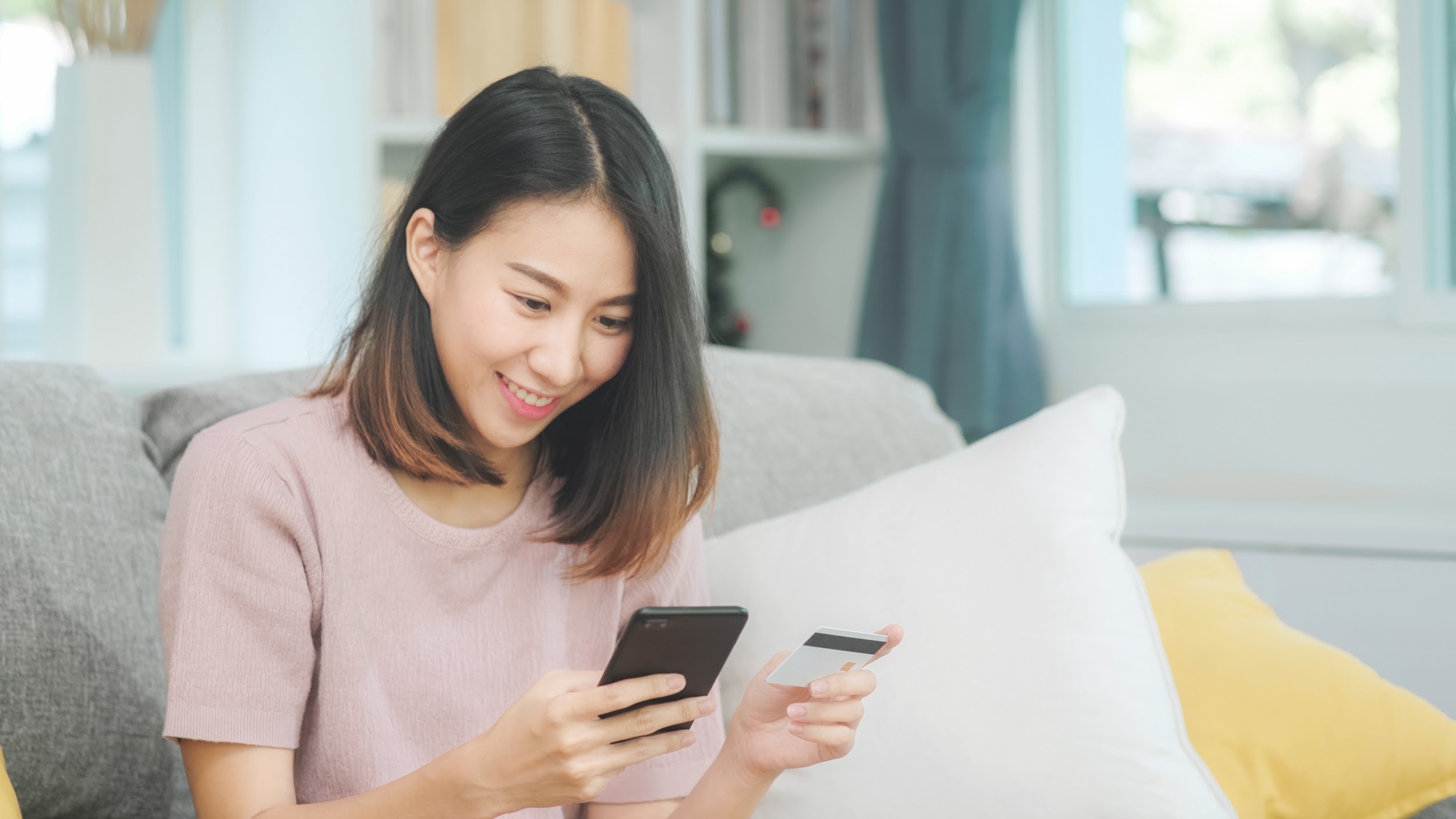 Young woman entering card details for an online purchase