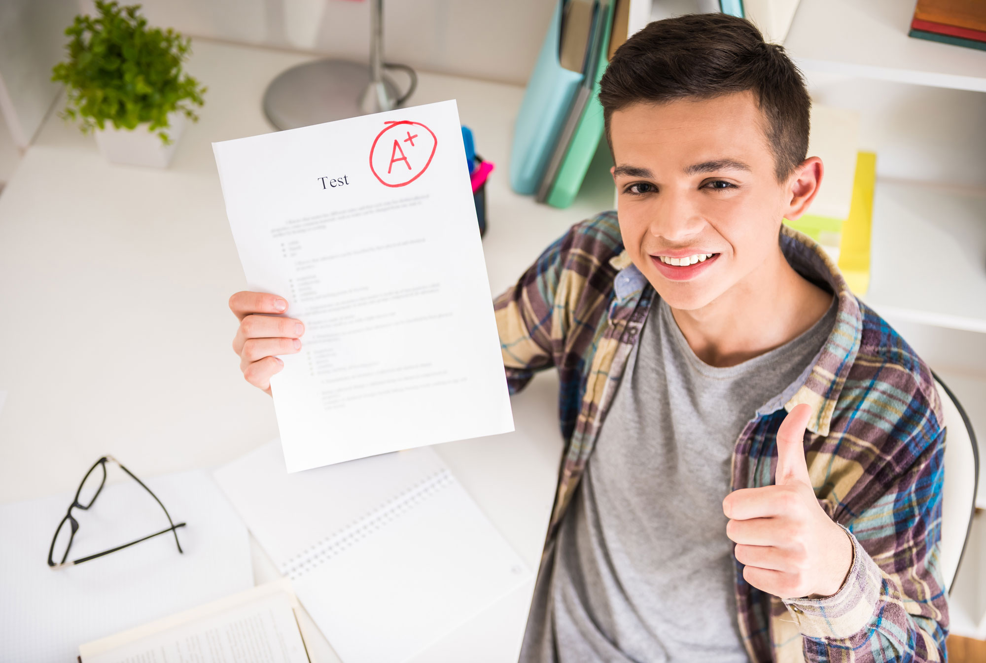 Student showing thumbs up after receiving good grades